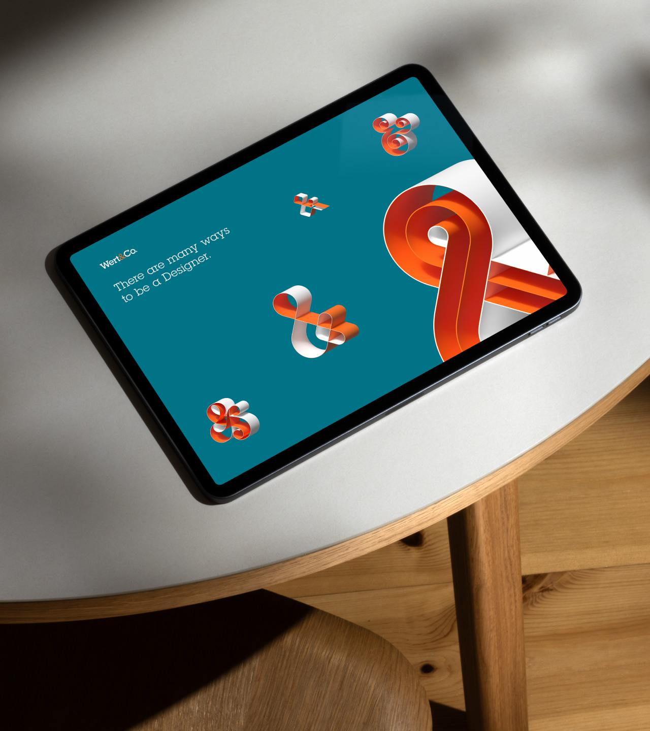 Wert&Co. website displayed on a monitor, featuring 3D ribbon-style ampersands and the tagline “There are many ways to be a Designer.”